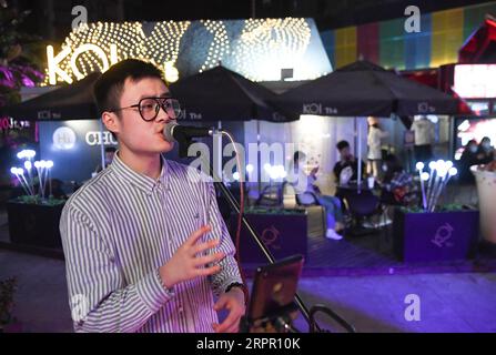 200324 -- CHONGQING, le 24 mars 2020 -- Un homme chante dans un bar du district de Jiangbei à Chongqing, dans le sud-ouest de la Chine, le 23 mars 2020. Dans le cadre des mesures strictes prises pour lutter contre le COVID-19, Chongqing a rouvert des bars, des restaurants et des vendeurs de collations aux citoyens afin de stimuler son économie nocturne de manière ordonnée. CHINE-CHONGQING-COVID-19-ÉCONOMIE NOCTURNE CN WANGXQUANCHAO PUBLICATIONXNOTXINXCHN Banque D'Images