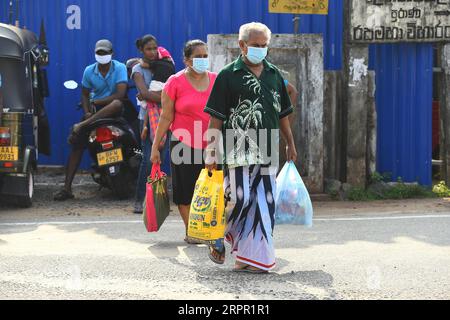 200324 -- COLOMBO, le 24 mars 2020 -- les clients font leurs courses lorsqu'un couvre-feu est levé temporairement pour permettre aux gens de se réapprovisionner en articles essentiels à Colombo, au Sri Lanka, le 24 mars 2020. Mardi, les autorités sri-lankaises ont déclaré trois districts, dont la capitale Colombo, comme zones à haut risque en raison de la propagation rapide du COVID-19 et y ont imposé un couvre-feu indéfini, a déclaré un communiqué du Bureau du Président. À la suite du couvre-feu, le communiqué a déclaré que des articles essentiels, y compris des médicaments, seront livrés aux portes des gens, car le public avait été interdit de quitter leurs maisons jusqu'à nouvel ordre. Banque D'Images