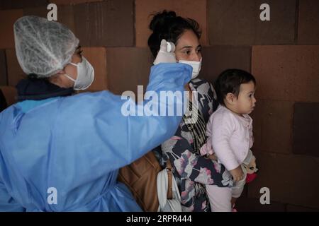 200326 -- BOGOTA, le 26 mars 2020 Xinhua -- un membre du personnel vérifie la température corporelle d'un passager dans un terminal d'autocars à Bogota, Colombie, le 24 mars 2020. Mercredi, les pays d’Amérique latine ont intensifié leurs mesures pour contenir la pandémie de COVID-19 alors que les taux d’infection continuaient à grimper. La Colombie, où 470 cas ont été signalés, a lancé un confinement national jusqu’en avril 13. Photo de Jhon Paz/Xinhua COLOMBIA-BOGOTA-COVID-19 PUBLICATIONxNOTxINxCHN Banque D'Images