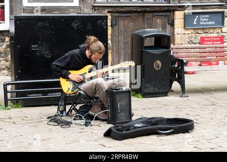 Street Entertainment jouant de la guitare Fender Stratocaster, Castle Hill, Lincoln City, Lincolnshire, Angleterre, ROYAUME-UNI Banque D'Images