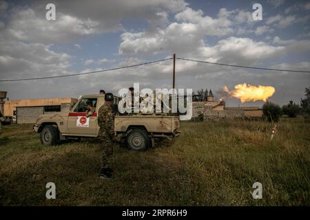 200328 -- TRIPOLI, le 28 mars 2020 -- des combattants du Gouvernement de l'entente nationale soutenus par l'ONU tirent une mitrailleuse lourde lors d'affrontements avec l'Armée nationale libyenne basée à l'est sur la ligne de front Al-Ramla à Tripoli, le 27 mars 2020. L'armée de l'est mène une campagne militaire depuis avril 2019 dans et autour de la capitale Tripoli, tentant de prendre le contrôle de la ville et de renverser le GNA reconnu par l'ONU du Premier ministre Fayez al-Sarraj. Photo de /Xinhua LIBYA-TRIPOLI-FRONTLINE AmruxSalahuddien PUBLICATIONxNOTxINxCHN Banque D'Images