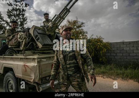 200328 -- TRIPOLI, le 28 mars 2020 -- des combattants du Gouvernement de l'entente nationale soutenus par l'ONU tirent une mitrailleuse lourde lors d'affrontements avec l'Armée nationale libyenne basée à l'est sur la ligne de front Al-Ramla à Tripoli, le 27 mars 2020. L'armée de l'est mène une campagne militaire depuis avril 2019 dans et autour de la capitale Tripoli, tentant de prendre le contrôle de la ville et de renverser le GNA reconnu par l'ONU du Premier ministre Fayez al-Sarraj. Photo de /Xinhua LIBYA-TRIPOLI-FRONTLINE AmruxSalahuddien PUBLICATIONxNOTxINxCHN Banque D'Images