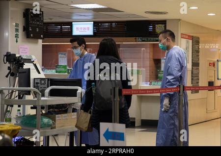 200330 -- TAIPEI, le 30 mars 2020 -- des membres du personnel vérifient l'état de santé d'une femme qui entre dans un hôpital à Taipei, dans le sud-est de la Chine, Taiwan, le 30 mars 2020. Le nombre total de cas de nouvelle maladie à coronavirus COVID-19 à Taiwan a augmenté de huit à 306, a déclaré lundi l agence de surveillance des épidémies de l île. CHINE-TAIPEI-COVID-19-VIE QUOTIDIENNE CN JINXLIWANG PUBLICATIONXNOTXINXCHN Banque D'Images