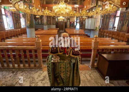 200330 -- BETHLÉEM, le 30 mars 2020 Xinhua -- Un prêtre dirige une messe dimanche vide dans une église orthodoxe de Beit Sahour près de la ville de Bethléem en Cisjordanie le 29 mars 2020. Pour la toute première fois, Raed al-Atrash, un palestinien de 54 ans de Bethléem, en Cisjordanie, a assisté à la messe du dimanche avec sa famille à travers une émission télévisée en direct, alors que les églises sont fermées dans le cadre des précautions contre la propagation du nouveau coronavirus. POUR ALLER AVEC Feature : les chrétiens en Palestine assistent à des prières en direct alors que les églises ferment sur les craintes du coronavirus photo de Luay Sababa/Xinhua MIDEAST-BETHLE Banque D'Images