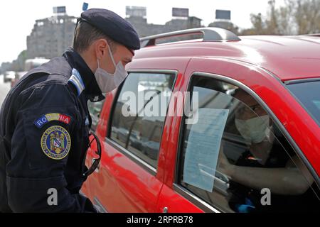 200331 -- BUCAREST, le 31 mars 2020 Xinhua -- Un gendarme roumain vérifie les gens pour trouver des papiers concernant leurs déplacements dans le centre-ville de Bucarest, Roumanie, le 30 mars 2020. La Roumanie a annoncé un confinement national à partir de mercredi matin. Le pays est entré en état d’urgence le 16 mars après que le nombre de cas de COVID-19 ait dépassé 100. Photo de Cristian Cristel/Xinhua ROMANIA-BUCAREST-COVID-19-CHECKING PUBLICATIONxNOTxINxCHN Banque D'Images