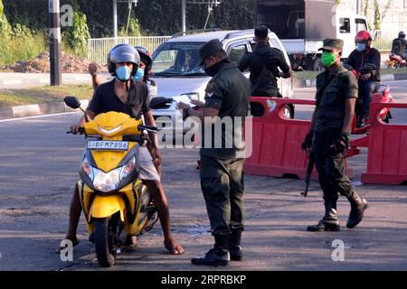 200331 -- COLOMBO, le 31 mars 2020 Xinhua -- Un soldat vérifie le couvre-feu de personnes à un point d'entrée à Colombo, Sri Lanka, le 30 mars 2020. Le Sri Lanka a jusqu’à présent confirmé 122 patients atteints de COVID-19, dont 14 se sont rétablis et ont été sortis de l’hôpital ces derniers jours, tandis que 104 autres sont sous observation dans les hôpitaux désignés à travers le pays. Le pays est toujours soumis à un couvre-feu imposé à l'échelle de l'île le 20 mars pour tenter d'empêcher la propagation de la pandémie. Photo de Gayan Sameera/Xinhua SRI LANKA-COVID-19-COUVRE-FEU-VIE PUBLICATIONxNOTxINxCHN Banque D'Images