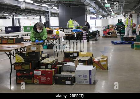 200401 -- LONDRES, le 1 avril 2020 Xinhua -- des volontaires préparent de la nourriture et des repas dans un centre de distribution dans le parking souterrain du Tottenham Hotspur Stadium à Londres, Grande-Bretagne, le 31 mars 2020. Le centre de distribution a été mis en place par l'organisme caritatif Edible London, travaillant en partenariat avec le Haringey Council, pour la distribution de nourriture aux groupes vulnérables et aux travailleurs du National Health Service NHS. Le gouvernement britannique continue de lutter contre l’épidémie de COVID-19, tandis que les autorités locales, les groupes communautaires et les organisations caritatives s’efforcent de fournir de la nourriture aux plus vulnérables de la société. Photo de Tim I. Banque D'Images