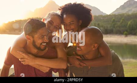 Portrait extérieur d'amis avec des hommes donnant des femmes piggybacks Banque D'Images