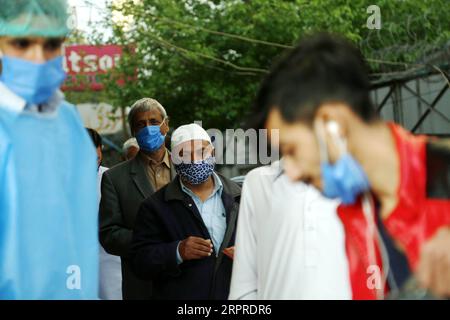200401 -- RAWALPINDI, 1 avril 2020 -- des gens font la queue pour acheter des masques à l'extérieur d'une pharmacie pendant le confinement comme mesure préventive contre le COVID-19 à Rawalpindi, dans la province du Punjab de l'est du Pakistan, le 1 avril 2020. Le nombre total de cas confirmés de COVID-19 au Pakistan est passé à 2 039, avec 26 décès signalés à travers le pays, selon les dernières données publiées sur le site Web du ministère de la Santé. PAKISTAN-RAWALPINDI-CORONAVIRUS-CONFINEMENT AhmadxKamal PUBLICATIONxNOTxINxCHN Banque D'Images