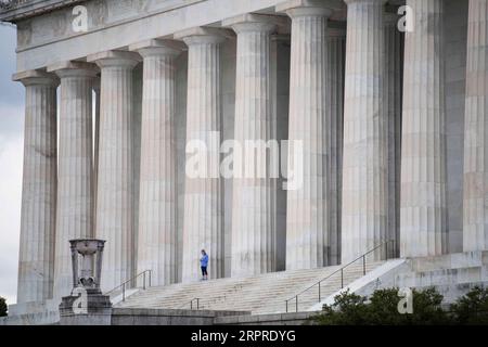 200402 -- WASHINGTON D.C., le 2 avril 2020 -- Une femme prend une courte pause après avoir fait du jogging au Lincoln Memorial pendant l'épidémie de COVID-19 à Washington D.C., États-Unis, le 1 avril 2020. Les États-Unis sont devenus la première nation à avoir enregistré plus de 200 000 infections à COVID-19 mercredi, selon un nouveau décompte de l’Université Johns Hopkins. U.S.-WASHINGTON D.C.-COVID-19 LiuxJie PUBLICATIONxNOTxINxCHN Banque D'Images