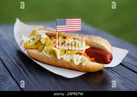 Hot-dog patriotique américain sur planche de bois avec drapeau des États-Unis. Célébration du jour de l'indépendance le 4 juillet aux États-Unis d'Amérique Banque D'Images