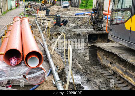 Vue de reconstruction de rue, tranchée profonde et large, tuyaux et puits souterrains remplacés, nouveaux tuyaux, excavatrice, tuyaux et tuyaux du système de déwatching Banque D'Images