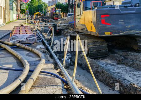 Vue de reconstruction de rue, tranchée profonde et large, tuyaux et puits souterrains remplacés, nouveaux tuyaux, excavatrice, tuyaux et tuyaux du système de déwatching Banque D'Images