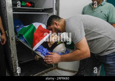 Tulkarm, Palestine. 05 septembre 2023. (NOTE DE LA RÉDACTION : l'image représente la mort) des proches du palestinien Ayed Abu Harb, 21 ans, membre du groupe militant du Jihad islamique, regardent son corps à la morgue de l'hôpital de Tulkarem, en Cisjordanie. Les responsables palestiniens de la santé affirment que les troupes israéliennes ont tué Abu Harb lors d’un raid de l’armée en Cisjordanie occupée. L’armée israélienne a déclaré que des Palestiniens armés avaient essuyé des tirs lors d’une opération visant à détruire un stock d’explosifs dans le camp de réfugiés. Crédit : SOPA Images Limited/Alamy Live News Banque D'Images