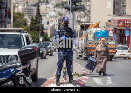 200406 -- BETHLÉEM, le 6 avril 2020 Xinhua -- Un policier palestinien monte la garde dans une rue au cours d'une campagne visant à saisir des conducteurs qui violent la loi d'urgence dans la ville de Bethléem en Cisjordanie, le 6 avril 2020. La Palestine a déclaré lundi le confinement complet de quatre villages en Cisjordanie, alors que le nombre de cas de COVID-19 en Palestine est passé à 252. Photo Luay Sababa/Xinhua MIDEAST-BETHLEHEM-COVID-19 PUBLICATIONxNOTxINxCHN Banque D'Images