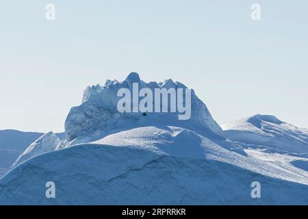 Gros plan d'un impressionnant iceberg flottant sous le soleil arctique dans le fjord glacé Ilulissat, site classé au patrimoine mondial de l'UNESCO. Ilulissat, Groenland Banque D'Images