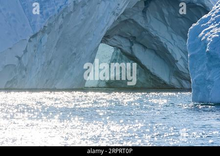 Gros plan d'un impressionnant iceberg flottant sous le soleil arctique dans le fjord glacé Ilulissat, site classé au patrimoine mondial de l'UNESCO. Ilulissat, Groenland, Danemark Banque D'Images