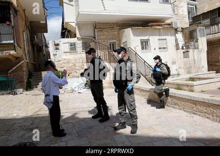 200408 -- JÉRUSALEM, 8 avril 2020 Xinhua -- des policiers israéliens portant des masques faciaux inspectent un piéton dans le quartier de Mea Shearim à Jérusalem, le 8 avril 2020. Israël a signalé six nouveaux cas de décès dus au nouveau coronavirus, portant le nombre de morts à 71, a déclaré mercredi le ministère de la Santé de l'État. Le ministère a ajouté qu’un total de 9 404 personnes en Israël ont été testées positives au COVID-19 jusqu’à présent. Photo de Gil Cohen Magen/Xinhua MIDEAST-JERUSALEM-COVID-19-COUVRE-FEU PUBLICATIONxNOTxINxCHN Banque D'Images