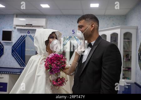 200411 -- PÉKIN, le 11 avril 2020 -- la mariée palestinienne, Shima al-Titi, ajuste le masque facial de son marié, Ishaq Musleh, avant de quitter le salon de beauté du camp de réfugiés palestiniens de Deheisheh près de Bethléem, en Cisjordanie, le 10 avril 2020. Photo de /Xinhua XINHUA PHOTOS DU JOUR LuayxSababa PUBLICATIONxNOTxINxCHN Banque D'Images