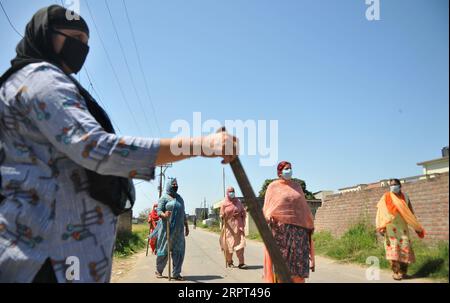 200411 -- PÉKIN, le 11 avril 2020 -- des femmes montent la garde pour restreindre l'entrée des étrangers au village de Chatha lors d'un confinement à Jammu, la capitale hivernale du Cachemire contrôlé par l'Inde, le 10 avril 2020. Str/XINHUA XINHUA PHOTOS DU JOUR Stringer PUBLICATIONxNOTxINxCHN Banque D'Images