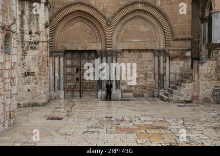 200411 -- PÉKIN, le 11 avril 2020 -- Un homme se tient devant une porte fermée de l'église du Saint-Sépulcre le vendredi Saint dans la vieille ville de Jérusalem au milieu de la nouvelle épidémie de coronavirus le 10 avril 2020. Photo de /Xinhua XINHUA PHOTOS DU JOUR MuammarxAwad PUBLICATIONxNOTxINxCHN Banque D'Images