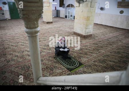 200411 -- PÉKIN, le 11 avril 2020 -- Un palestinien lit le Coran dans une mosquée vide pendant la prière du vendredi après sa fermeture par précaution contre la propagation du COVID-19, dans la ville de Hébron en Cisjordanie, le 10 avril 2020. Photo de /Xinhua XINHUA PHOTOS DU JOUR MamounxWazwaz PUBLICATIONxNOTxINxCHN Banque D'Images