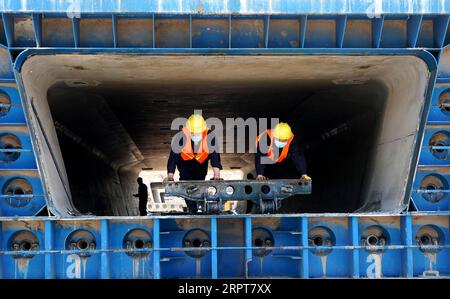 200412 -- ZHENGZHOU, le 12 avril 2020 -- le personnel travaille dans une zone de production de poutres qui fait partie du chantier de construction d'une ligne de chemin de fer à Zhengzhou, dans la province du Henan du centre de la Chine, le 12 avril 2020. Avec des mesures strictes contre la COVID-19 en place, la construction de la section Zhengzhou de la ligne ferroviaire de Zhengzhou à Jinan, province du Shandong dans l est de la Chine, a progressé de manière régulière. Le chemin de fer de 380 km est conçu pour fonctionner à la vitesse de 350 km/h. CHINE-ZHENGZHOU-CONSTRUCTION FERROVIAIRE À GRANDE VITESSE CN LIXAN PUBLICATIONXNOTXINXCHN Banque D'Images