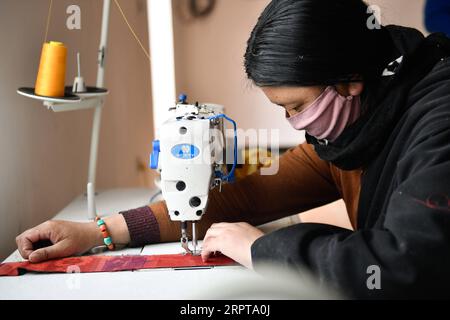 200413 -- XINING, le 13 avril 2020 -- Une femme locale coud des ornements de tissu dans un atelier de la préfecture autonome tibétaine de Yushu, province du Qinghai au nord-ouest de la Chine, le 3 avril 2020. Xinhua Headlines : dix ans après le séisme, la ville montagneuse de la Chine se lève de cendres ZhangxLong PUBLICATIONxNOTxINxCHN Banque D'Images