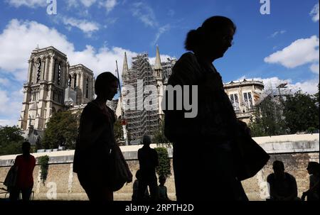 200415 -- PARIS, le 15 avril 2020 -- une photo de dossier prise le 16 août 2019 montre des gens qui passent devant la cathédrale notre-Dame en réparation à Paris, en France. La cathédrale du centre de Paris a pris feu le 15 avril dernier. FRANCE-PARIS-NOTRE DAME-FEU-UN AN ANNIVERSAIRE GAOXJING PUBLICATIONXNOTXINXCHN Banque D'Images