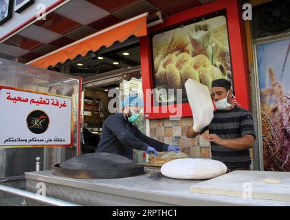 200415 -- GAZA, 15 avril 2020 Xinhua -- des travailleurs palestiniens portant des masques de protection travaillent dans une boulangerie avec une chambre de désinfection dans la ville de Gaza, le 15 avril 2020. La Palestine a déclaré mercredi que 40 nouveaux cas de COVID-19 ont été confirmés sur son territoire, ce qui porte le nombre total à 369. Photo de Rizek Abdeljawad/Xinhua MIDEAST-GAZA CITY-COVID-19-MEASURES PUBLICATIONxNOTxINxCHN Banque D'Images