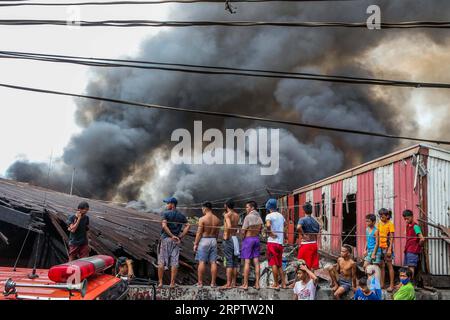 200418 -- MANILLE, le 18 avril 2020 Xinhua -- les gens regardent la fumée couler d'un incendie engloutir un bidonville à Manille, aux Philippines, le 18 avril 2020. Des centaines de familles ici ont été déplacées samedi à cause de l'incendie. Xinhua/Rouelle Umali PHILIPPINES-MANILA-TAUDIS-FIRE PUBLICATIONxNOTxINxCHN Banque D'Images