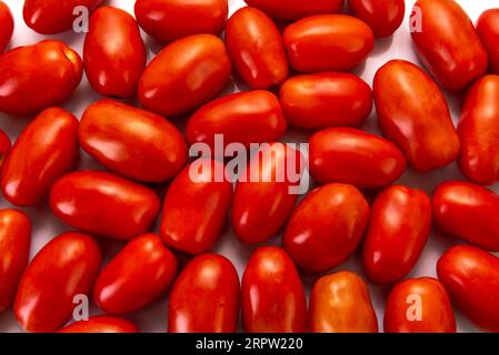 Tomates prunes rouges disposées en arrière-plan vu en vue de dessus plein cadre Banque D'Images