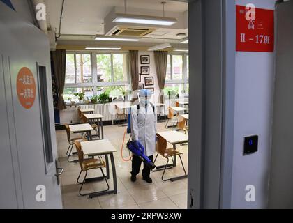 200421 -- BEIJING, le 21 avril 2020 -- un membre du personnel désinfecte une salle de classe à l'école nationale de Beijing à Beijing, capitale de la Chine, le 21 avril 2020. Récemment, l'École nationale de jour de Pékin a effectué une opération complète de désinfection et de stérilisation sur le campus, et a mis en place des portes intelligentes de mesure de la température, des dispositifs intelligents de désinfection des mains dans des zones clés du campus pour assurer le retour sûr et ordonné des enseignants et des étudiants. CHINE-PÉKIN-LYCÉE-DÉSINFECTION CN RENXCHAO PUBLICATIONXNOTXINXCHN Banque D'Images