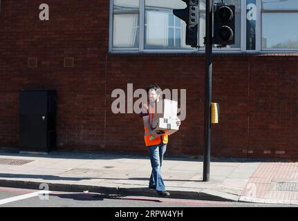200421 -- LONDRES, le 21 avril 2020 -- Un livreur livre des colis à Londres, en Grande-Bretagne, le 21 avril 2020. 823 autres personnes testées positives au COVID-19 sont décédées dans des hôpitaux en Grande-Bretagne lundi après-midi, ce qui porte le nombre total de décès liés au coronavirus à 17 337, a déclaré mardi le ministère de la Santé et des Affaires sociales. Mardi matin, 129 044 personnes ont été testées positives au COVID-19, marquant une augmentation quotidienne de 4 301, a déclaré le département. BRETAGNE-LONDRES-COVID-19 HanxYan PUBLICATIONxNOTxINxCHN Banque D'Images