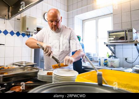 200425 -- ROSENHEIM, le 25 avril 2020 Xinhua -- Michael Haldek, l'un des propriétaires du restaurant Fischkueche, prépare des repas gratuits dans la cuisine du restaurant de Rosenheim, dans le sud de l'Allemagne, le 24 avril 2020. Alors que le COVID-19 a frappé Rosenheim, dans le sud de l’Allemagne, Fischkueche Fish Kitchen, un restaurant avec une histoire de plus de 100 ans, a fourni près de 2 000 repas gratuits avec livraison gratuite par des bénévoles aux populations locales ayant besoin d’aide au cours des cinq dernières semaines. Photo de Kevin Voigt/Xinhua ALLEMAGNE-ROSENHEIM-COVID-19-REPAS GRATUITS PUBLICATIONxNOTxINxCHN Banque D'Images