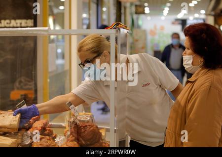 200430 -- BUCAREST, le 30 avril 2020 Xinhua -- Un vendeur portant un masque facial vend des marchandises sur un marché de Bucarest, en Roumanie, le 29 avril 2020. La Roumanie va lever le confinement national après le 15 mai, date de la fin de l'état d'urgence, a annoncé récemment le président Klaus Iohannis. Photo de Cristian Cristel/Xinhua ROUMANIE-BUCAREST-COVID-19-CONFINEMENT NATIONAL PUBLICATIONxNOTxINxCHN Banque D'Images