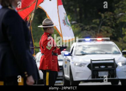 200430 -- SURREY CANADA, le 30 avril 2020 Xinhua -- des véhicules de police passent devant un agent de la Gendarmerie royale du Canada de la GRC lors d'un cortège à Surrey, au Canada, le 30 avril 2020. Un cortège commémoratif des premiers intervenants a eu lieu jeudi dans le Surrey du Canada pour honorer les victimes de la fusillade de masse meurtrière de la Nouvelle-Écosse. Photo de Liang Sen/Xinhua CANADA -SURREY-MEMORIAL MOTORCADE-NOVA SCOTIA SHOOTING PUBLICATIONxNOTxINxCHN Banque D'Images