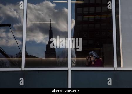 200510 -- NEW YORK, le 10 mai 2020 -- Un travailleur de la santé du NYU Langone Medical Center parle au téléphone alors que l'Empire State Building se reflète dans une fenêtre au milieu de l'épidémie de COVID-19 à New York, aux États-Unis, le 9 mai 2020. Le nombre de cas de COVID-19 aux États-Unis a atteint 1 300 079 à partir de 3:32 h 1932 GMT samedi, selon le Center for Systems Science and Engineering CSSE de l’Université Johns Hopkins. Pendant ce temps, le nombre de morts de la maladie dans le pays a atteint 78 320. Photo par /Xinhua U.S.-COVID-19 CAS-UPDATE MichaelxNagle PUBLICATIONxNOTxINxCHN Banque D'Images