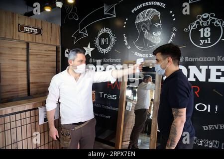 200511 -- ANKARA, 11 mai 2020 Xinhua -- Un coiffeur vérifie la température d'un homme dans un salon de coiffure à Ankara, Turquie, le 11 mai 2020. La Turquie a signalé lundi 1 114 nouveaux cas de COVID-19 et 55 décès supplémentaires, ce qui porte le nombre total de cas confirmés à 139 771 et le nombre de décès à 3 841. Photo Mustafa Kaya/Xinhua TURQUIE-ANKARA-COVID-19-SALON DE COIFFURE PUBLICATIONxNOTxINxCHN Banque D'Images