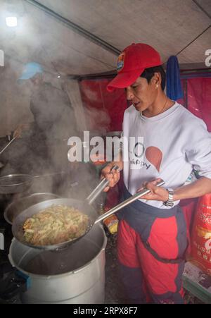 200513 -- MONT QOMOLANGMA, le 13 mai 2020 -- Un chef cuisinier cuisine au camp avancé à 6 500 mètres d'altitude sur le mont Qomolangma, le 10 mai 2020. Pour faire face à la haute altitude et à la basse pression au camp avancé, les chefs utilisent des autocuiseurs pour préparer la nourriture. InTibet CHINE-TIBET-MONT QOMOLANGMA-ADVANCE CAMP-MEAL CN SunxFei PUBLICATIONxNOTxINxCHN Banque D'Images