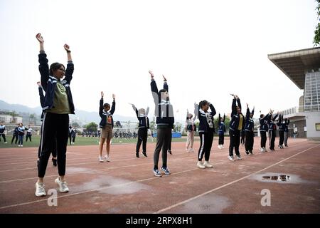 200513 -- CHONGQING, le 13 mai 2020 -- des élèves s'échauffent pendant un cours de gym dans une école secondaire de la municipalité de Chongqing, dans le sud-ouest de la Chine, le 13 mai 2020. Les écoles de Chongqing ont progressivement repris les cours de gym, avec une protection adéquate contre les épidémies pour les élèves. CHINE-CHONGQING-ÉCOLE-GYM CLASSE CN TANGXYI PUBLICATIONXNOTXINXCHN Banque D'Images