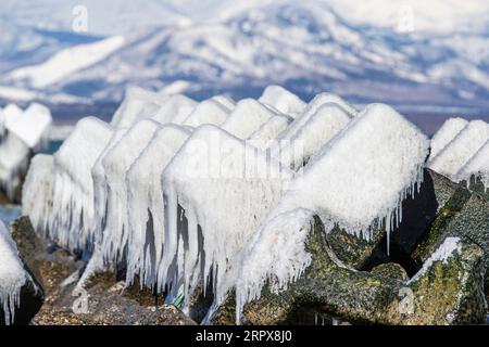 Blocs de béton couverts de glace comme brise-vagues sur la plage japonaise en hiver. Île de Hokkaido, Japon Banque D'Images