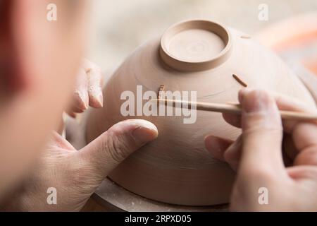 200517 -- HANGZHOU, le 17 mai 2020 -- Liu Jie travaille sur la réplique de Bakohan dans son atelier de Longquan, province du Zhejiang dans l'est de la Chine, le 7 mai 2020. Liu Jie, 35 ans et céramiste renommé à Longquan, a commencé à reproduire Bakohan depuis 2019. Il a jusqu'à présent réalisé plus de 500 répliques dans un effort pour approcher la perfection. Je souhaite reproduire sa beauté. A dit Liu. Bakohan est un bol à thé fabriqué à Longquan, en Chine, et offert au Japon pendant la dynastie des Song du Sud 1127-1279. Pendant l'ère de la dynastie Ming 1368-1644, Bakouhan a été trouvé pour avoir des fissures et a ensuite été envoyé en Chine pour être réparé. Le bol est maintenant disponible Banque D'Images