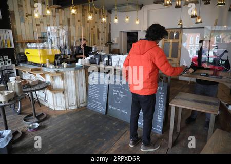 200518 -- LONDRES, le 18 mai 2020 Xinhua -- Un homme achète un café dans un café de Londres, Grande-Bretagne, le 17 mai 2020. Certains restaurants, cafés et autres magasins de restauration en Grande-Bretagne ont progressivement repris leurs activités avec des mesures préventives telles que le maintien de la distanciation sociale après que le gouvernement britannique ait publié une stratégie d’assouplissement progressif du nouveau confinement du coronavirus. Photo de Tim Ireland/Xinhua BRITAIN-LONDRES-COVID-19-RESTAURANT-ROPENING PUBLICATIONxNOTxINxCHN Banque D'Images