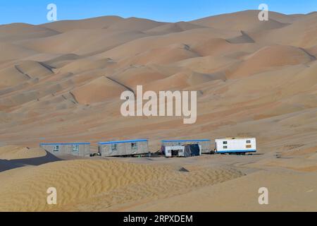 200518 -- YULI, 18 mai 2020 -- une photo prise le 16 mai 2020 montre des camps près du chantier de construction d'une autoroute dans le désert de Taklimakan, dans la région autonome ouïgoure du Xinjiang, au nord-ouest de la Chine. La construction de l'autoroute Yuli-Qiemo, la troisième route nord-sud traversant le désert de Taklimakan, est entrée dans la ruée finale. Les travailleurs de China Communications Construction Company Ltd. Travaillent sur la plus grande dune de ce projet, avec un volume estimé à 1,2 millions de mètres cubes de sable à traiter. Ils ont établi des camps à côté de la dune pour la commodité du travail, et reçoivent les nécessités quotidiennes sur Banque D'Images