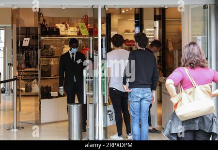 200518 -- ROME, le 18 mai 2020 -- les gens font la queue pour prendre une mesure de la température corporelle avant d'entrer dans un centre commercial à Rome, Italie, le 18 mai 2020. Lundi, le troisième et plus grand assouplissement du confinement de dix semaines est entré en vigueur. Magasins, restaurants, bars, salons de coiffure, salons de beauté, les musées et les exploitants de bord de mer sont tous autorisés à rouvrir, à condition de respecter les règles de distanciation sociale entre le personnel et les membres du public et de désinfection des installations. Les Italiens sont également autorisés à se déplacer dans la région où ils vivent. ITALIE-ROME-COVID-19-ASSOUPLISSEMENT DU CONFINEMENT ChengxTingting PUBLICATIONxNOTxINxC Banque D'Images