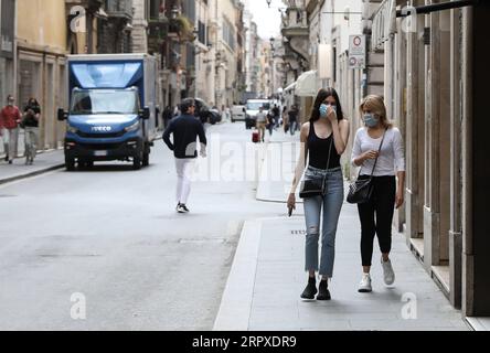 200518 -- ROME, le 18 mai 2020 -- des personnes portant des masques se promènent rue Condotti à Rome, Italie, le 18 mai 2020. Lundi, le troisième et plus grand assouplissement du confinement de dix semaines est entré en vigueur. Magasins, restaurants, bars, salons de coiffure, salons de beauté, les musées et les exploitants de bord de mer sont tous autorisés à rouvrir, à condition de respecter les règles de distanciation sociale entre le personnel et les membres du public et de désinfection des installations. Les Italiens sont également autorisés à se déplacer dans la région où ils vivent. ITALIE-ROME-COVID-19-ASSOUPLISSEMENT DU CONFINEMENT ChengxTingting PUBLICATIONxNOTxINxCHN Banque D'Images