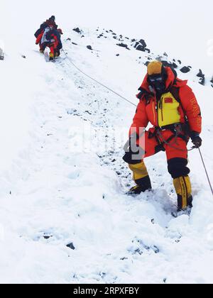 200521 -- CAMP DE BASE DU MONT QOMOLANGMA, le 21 mai 2020 -- des géomètres chinois sont en route pour se replier vers le camp avancé à une altitude de 6 500 mètres sur le mont Qomolangma, le 21 mai 2020. L'équipe chinoise d'alpinisme a encore retardé son plan pour atteindre le sommet du mont. Qomolangma le 22 mai pour mesurer avec précision sa hauteur en raison des mauvaises conditions météorologiques. Situé à la frontière sino-népalaise, le mont Qomolangma est le plus haut sommet du monde, avec sa partie nord située dans le Xigaze de la région autonome du Tibet du sud-ouest de la Chine. INTIBETCHINA-TIBET-MONT QOMOLANGMA-REMESURE-DELAY CN TASHIXTSERING PUB Banque D'Images