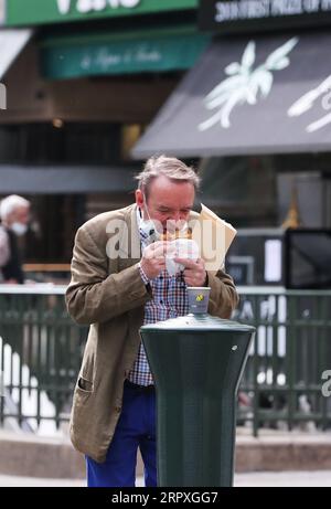 200522 -- PARIS, le 22 mai 2020 -- Un homme prend son petit déjeuner dans une rue de Paris, France, le 22 mai 2020. La France a décidé d’organiser le deuxième tour retardé des élections municipales le 28 juin, qui, selon le Premier ministre Edouard Philippe vendredi, est réversible si la situation de l’épidémie de coronavirus se retourne contre elle. FRANCE-PARIS-COVID-19-ÉLECTIONS MUNICIPALES GaoxJing PUBLICATIONxNOTxINxCHN Banque D'Images