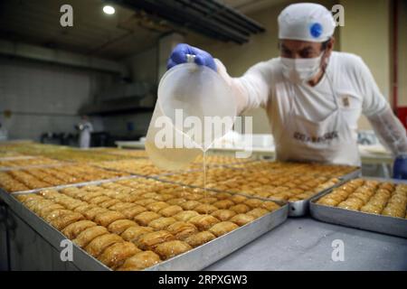 200523 -- ANKARA, le 23 mai 2020 -- Un boulanger prépare le baklava traditionnel turc à Halk Bread Factory, une boulangerie à Ankara, en Turquie, le 22 mai 2020. Les Turcs aiment prendre des desserts à l'Iftar, le repas du soir où les musulmans rompent leur jeûne pendant le mois islamique du Ramadan. Photo de /Xinhua TURQUIE-ANKARA-DESSERTS TRADITIONNELS MustafaxKaya PUBLICATIONxNOTxINxCHN Banque D'Images